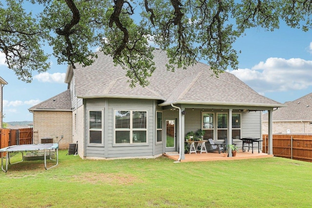 958 Pink Granite Blvd, Dripping Springs, TX 78620 - rear view of property featuring a trampoline, a fenced backyard, a patio, and roof with shingles