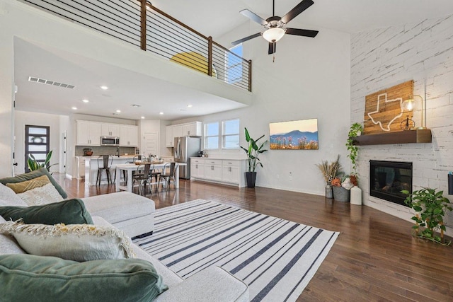 958 Pink Granite Blvd, Dripping Springs, TX 78620 - living area featuring a high ceiling, ceiling fan, dark wood-style floors, and a stone fireplace