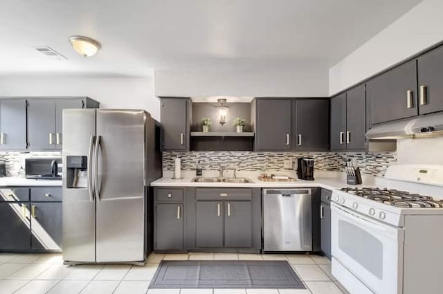 313 Rowland Dr, Austin, TX 78745 - kitchen featuring stainless steel appliances, under cabinet range hood, decorative backsplash, open shelves, and light countertops