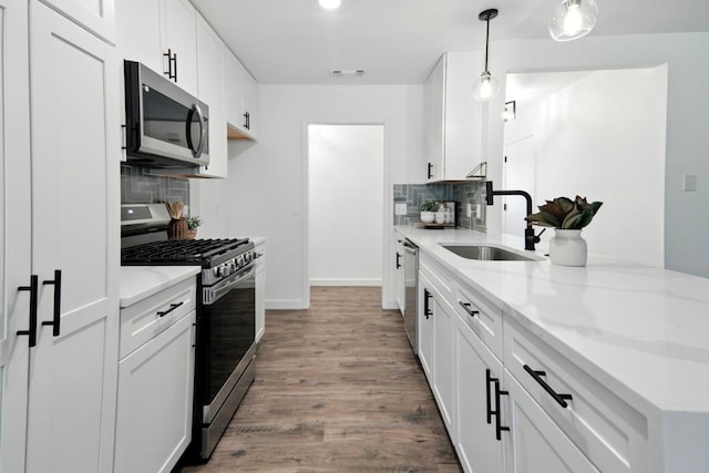 2207 Emerald Isle Dr, Leander, TX 78641 - kitchen with stainless steel appliances, tasteful backsplash, wood finished floors, and white cabinets
