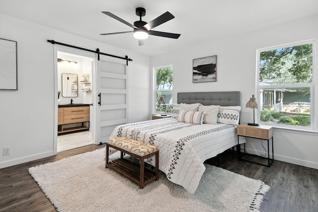 2207 Emerald Isle Dr, Leander, TX 78641 - bedroom with a barn door, wood finished floors, connected bathroom, and a ceiling fan