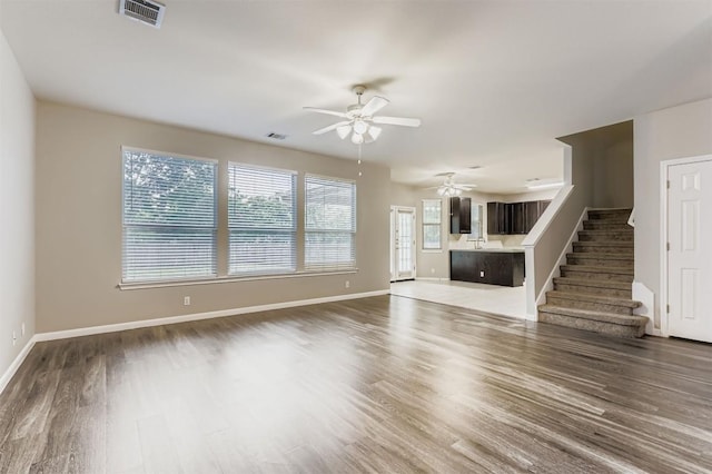 6050 Almelo Dr, Round Rock, TX 78681 - unfurnished living room featuring ceiling fan, wood finished floors, and stairs