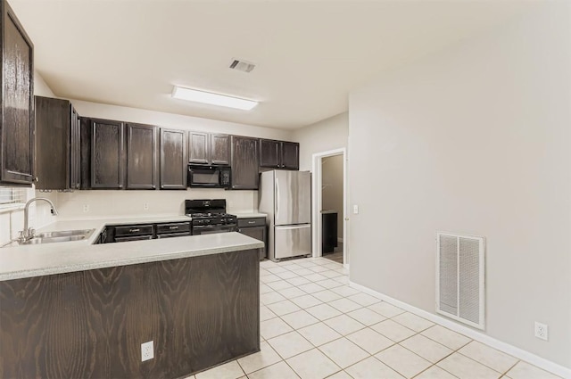 6050 Almelo Dr, Round Rock, TX 78681 - kitchen with black appliances, dark brown cabinetry, light countertops, and light tile patterned floors
