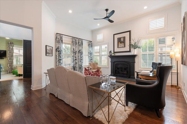 205 Versilia Cir, Lakeway, TX 78734 - living area featuring a fireplace with raised hearth, ceiling fan, dark wood finished floors, healthy amount of natural light, and ornamental molding