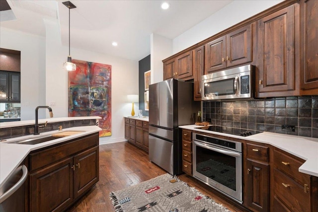 205 Versilia Cir, Lakeway, TX 78734 - kitchen featuring stainless steel appliances, dark wood-style flooring, backsplash, light countertops, and decorative light fixtures
