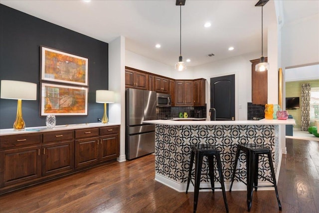 205 Versilia Cir, Lakeway, TX 78734 - kitchen featuring appliances with stainless steel finishes, light countertops, backsplash, dark wood-style flooring, and recessed lighting