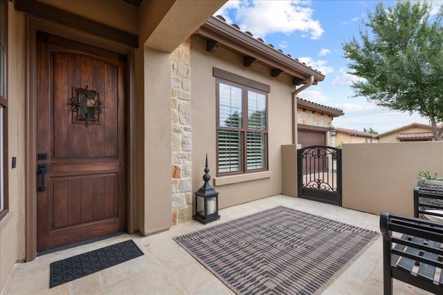 205 Versilia Cir, Lakeway, TX 78734 - view of exterior entry featuring stone siding, a gate, and stucco siding