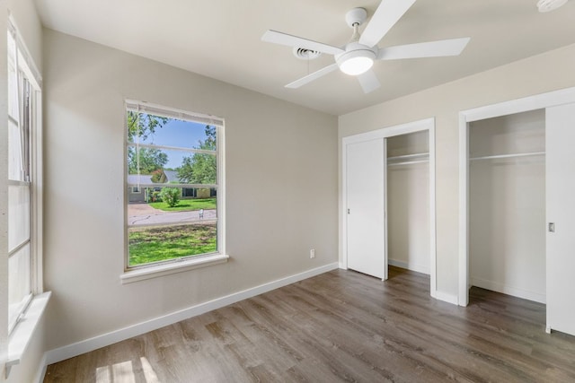 5302 Robinsdale Ln, Austin, TX 78723 - unfurnished bedroom with multiple closets, wood finished floors, and a ceiling fan