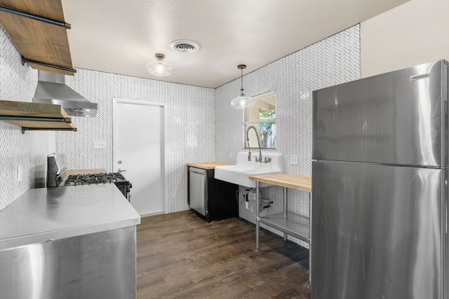 5302 Robinsdale Ln, Austin, TX 78723 - kitchen featuring freestanding refrigerator, stove, dark wood-style flooring, open shelves, and wall chimney range hood