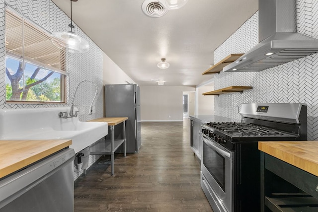 5302 Robinsdale Ln, Austin, TX 78723 - kitchen featuring wood counters, wall chimney range hood, appliances with stainless steel finishes, open shelves, and vaulted ceiling