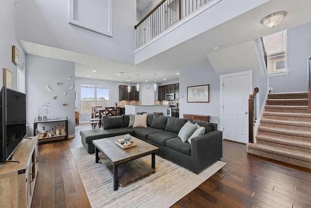 16216 Travesia Way, Austin, TX 78728 - living area with a towering ceiling, stairway, and dark wood-style floors