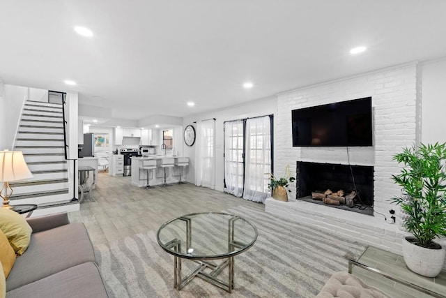 3520 Highland View Dr, Austin, TX 78731 - living room with stairway, light wood-style flooring, a brick fireplace, and recessed lighting