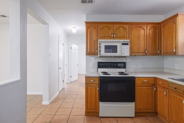 4108 Lewis Ln Unit A & B, Austin, TX 78756 - kitchen featuring white microwave, range with electric cooktop, light tile patterned floors, and light countertops