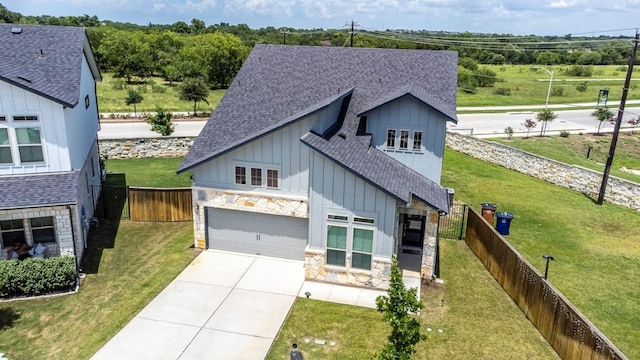 2800 Sebring Cir, Austin, TX 78747 - modern farmhouse style home featuring board and batten siding, a shingled roof, concrete driveway, stone siding, and a fenced backyard