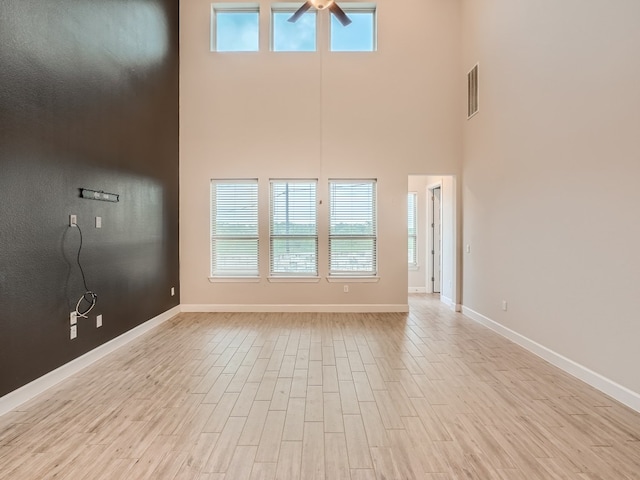 2800 Sebring Cir, Austin, TX 78747 - unfurnished living room featuring a high ceiling, ceiling fan, and light wood-style floors