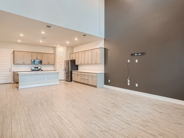 2800 Sebring Cir, Austin, TX 78747 - kitchen featuring appliances with stainless steel finishes, light wood-type flooring, light countertops, recessed lighting, and tasteful backsplash