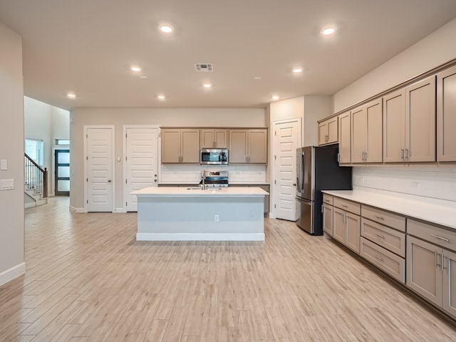 2800 Sebring Cir, Austin, TX 78747 - kitchen with appliances with stainless steel finishes, decorative backsplash, light countertops, an island with sink, and recessed lighting