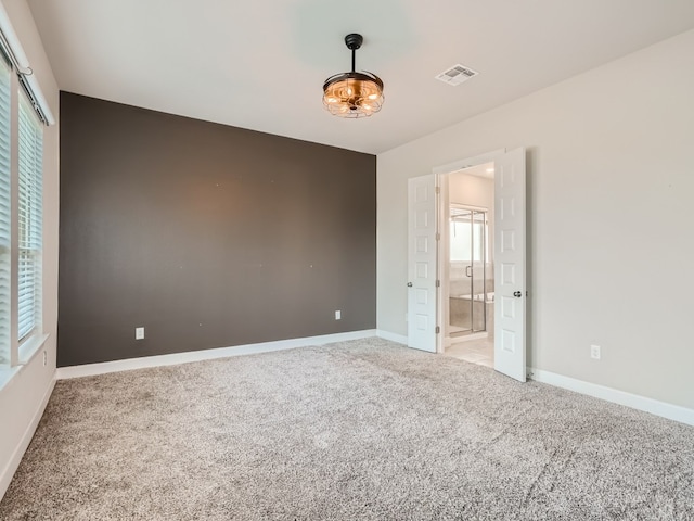2800 Sebring Cir, Austin, TX 78747 - unfurnished bedroom with light colored carpet, multiple windows, and ensuite bath