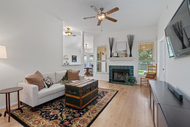 208 Meadowside Dr, Hutto, TX 78634 - living room with a tile fireplace, light wood-style flooring, healthy amount of natural light, and ceiling fan