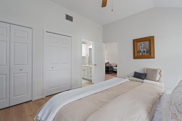 208 Meadowside Dr, Hutto, TX 78634 - bedroom featuring light wood-type flooring, multiple closets, lofted ceiling, connected bathroom, and a ceiling fan