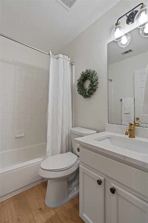 208 Meadowside Dr, Hutto, TX 78634 - bathroom featuring vanity, wood finished floors, and shower / tub combo with curtain