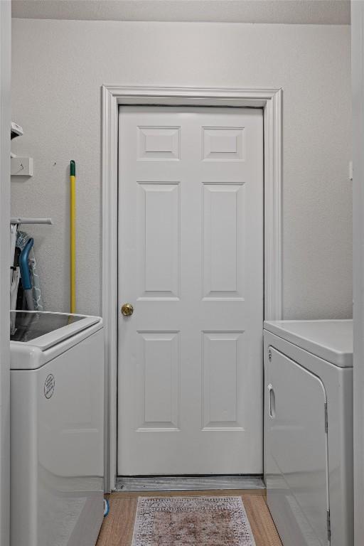 208 Meadowside Dr, Hutto, TX 78634 - washroom with washer and clothes dryer and light wood finished floors