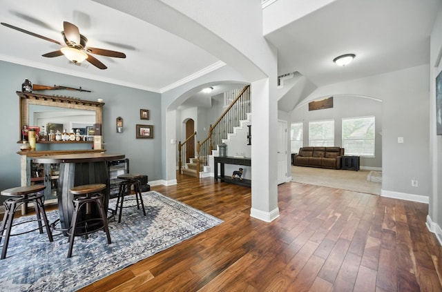 1208 Pine Forest Cir, Round Rock, TX 78665 - dining space with arched walkways, a ceiling fan, stairway, a dry bar, and dark wood-type flooring