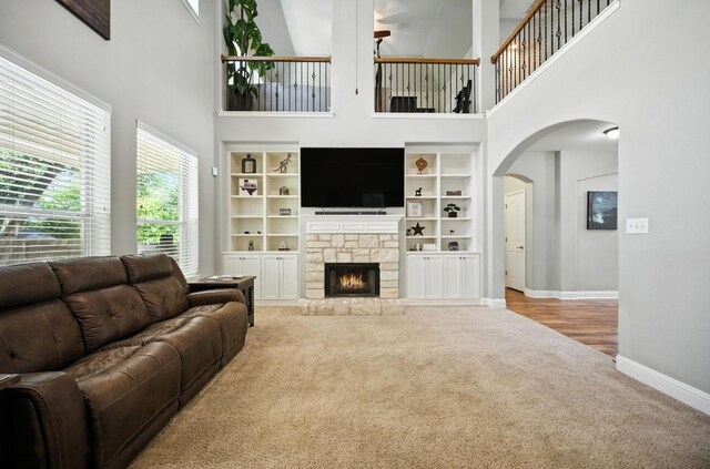 1208 Pine Forest Cir, Round Rock, TX 78665 - carpeted living room featuring a high ceiling, arched walkways, and a fireplace