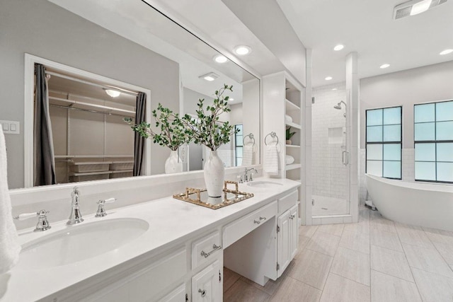 7204 Guava Cv, Austin, TX 78750 - bathroom with a shower stall, double vanity, a spacious closet, a freestanding bath, and recessed lighting