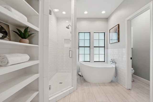 7204 Guava Cv, Austin, TX 78750 - full bath with a shower stall, a soaking tub, wainscoting, tile walls, and recessed lighting