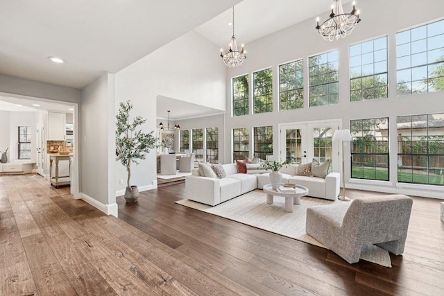 7204 Guava Cv, Austin, TX 78750 - living room featuring a chandelier, a high ceiling, wood-type flooring, recessed lighting, and french doors