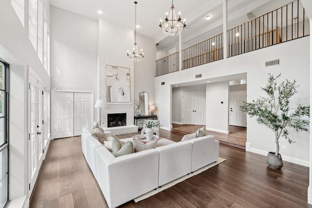 7204 Guava Cv, Austin, TX 78750 - living area with a towering ceiling, a chandelier, wood finished floors, recessed lighting, and a brick fireplace