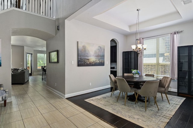 30872 Schlather Ln, Bulverde, TX 78163 - dining space with arched walkways, a chandelier, a raised ceiling, and wood finished floors