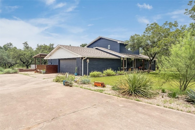 10133 Oliver Dr, Austin, TX 78737 - view of side of home featuring concrete driveway, a garage, brick siding, and covered porch