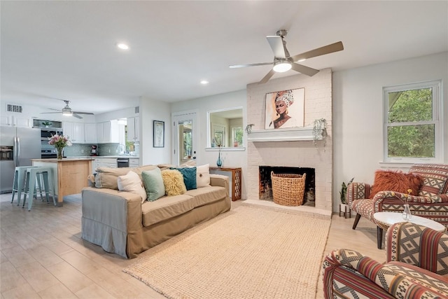 10133 Oliver Dr, Austin, TX 78737 - living room featuring a ceiling fan, plenty of natural light, light wood-style flooring, a fireplace, and recessed lighting