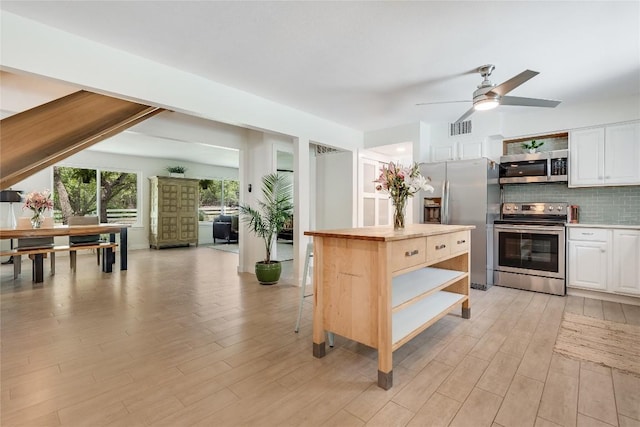 10133 Oliver Dr, Austin, TX 78737 - kitchen featuring stainless steel appliances, open shelves, ceiling fan, white cabinets, and tasteful backsplash
