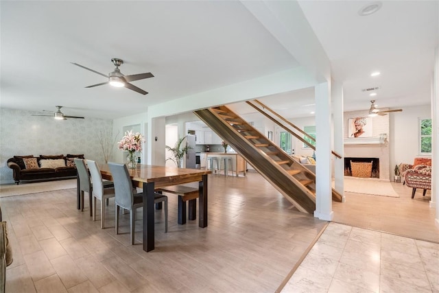 10133 Oliver Dr, Austin, TX 78737 - dining room with ceiling fan, a large fireplace, stairs, wood finished floors, and recessed lighting