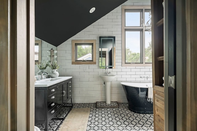 913 Christopher St, Austin, TX 78704 - full bath featuring a soaking tub, lofted ceiling, tile walls, and plenty of natural light
