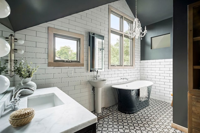 913 Christopher St, Austin, TX 78704 - full bath with tile walls, a freestanding bath, a chandelier, and lofted ceiling