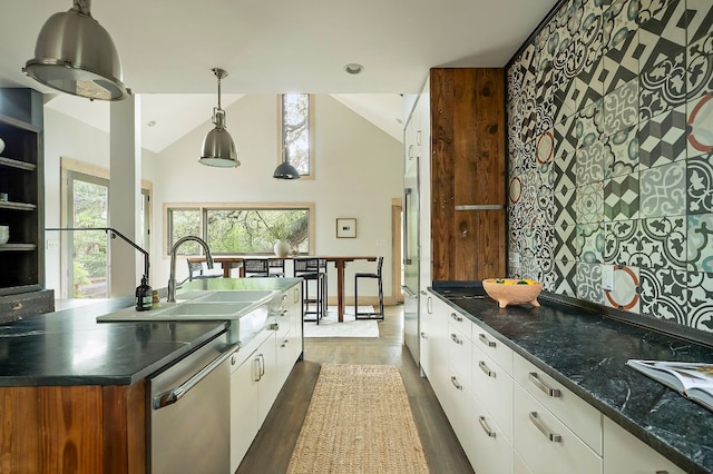 913 Christopher St, Austin, TX 78704 - kitchen with dishwasher, white cabinets, wood finished floors, hanging light fixtures, and high vaulted ceiling