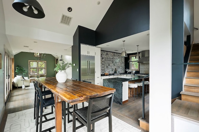 913 Christopher St, Austin, TX 78704 - dining space featuring vaulted ceiling, stairway, light wood-style floors, and a chandelier