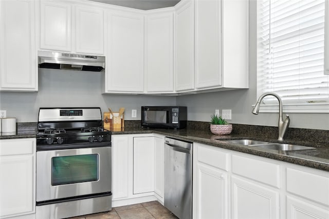 12007 Sky W Dr, Austin, TX 78758 - kitchen featuring under cabinet range hood, stainless steel appliances, white cabinetry, and dark stone countertops