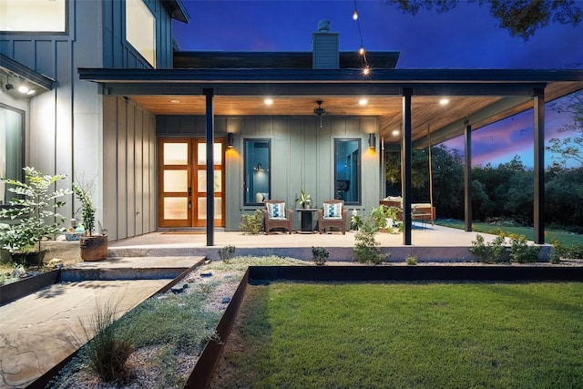 11420 Rim Rock Trl, Austin, TX 78737 - rear view of house with board and batten siding, a lawn, and a chimney