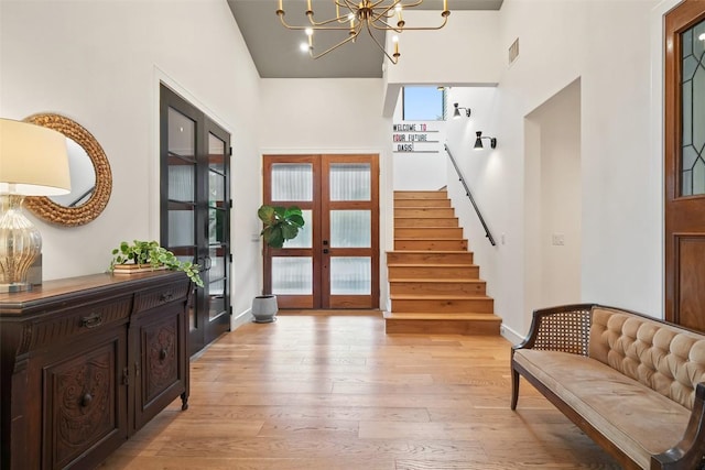 11420 Rim Rock Trl, Austin, TX 78737 - entryway with light wood-style floors, stairway, a towering ceiling, a chandelier, and french doors