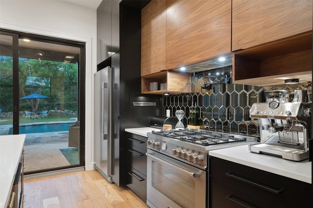 11420 Rim Rock Trl, Austin, TX 78737 - kitchen featuring modern cabinets, appliances with stainless steel finishes, backsplash, light countertops, and dark cabinetry