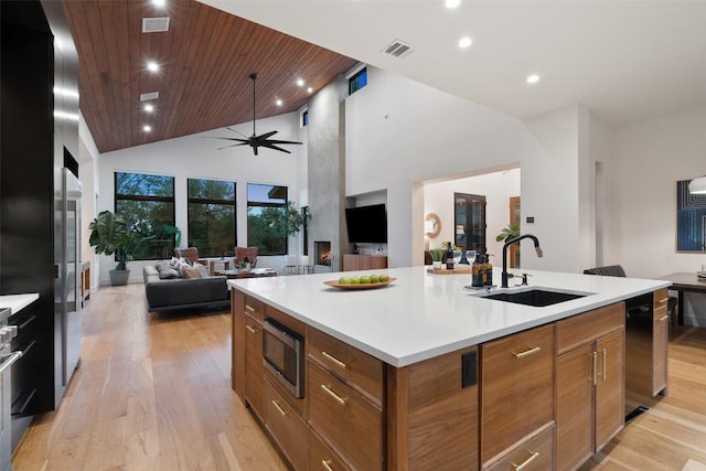 11420 Rim Rock Trl, Austin, TX 78737 - kitchen featuring appliances with stainless steel finishes, open floor plan, a kitchen island with sink, light wood finished floors, and recessed lighting
