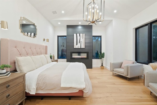 11420 Rim Rock Trl, Austin, TX 78737 - bedroom with vaulted ceiling, light wood-style flooring, a chandelier, recessed lighting, and a fireplace