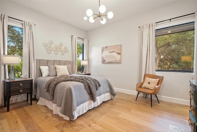 11420 Rim Rock Trl, Austin, TX 78737 - bedroom with a chandelier, light wood-style flooring, and multiple windows