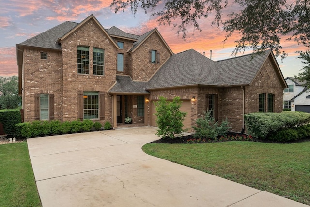 12417 Mediterra Pl, Austin, TX 78732 - view of front of house featuring brick siding, a shingled roof, driveway, a lawn, and an attached garage