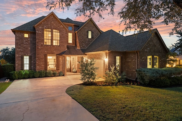 12417 Mediterra Pl, Austin, TX 78732 - view of front of property with brick siding, driveway, a garage, a front yard, and a shingled roof